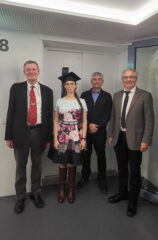 The photo shows Melanie Sigl, Prof. Meyer-Wegener, Prof. Mitschang, and Prof. Lenz after the doctoral examination. They are standing next to each other and looking straight at the camera. Melanie Sigl is wearing a doctoral cap.